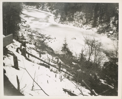 Trees cut down on state land at the proposed site of the Panther Mountain Dam with the Moose River in the background, in winter. Paul Schaefer and the Adirondack Moose River Committee took this picture as part of a trip they made to record illegal tree cutting activity relating to the Panther Mountain Dam, circa 1946.