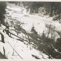 Trees cut down on state land at the proposed site of the Panther Mountain Dam with the Moose River in the background, in winter. Paul Schaefer and the Adirondack Moose River Committee took this picture as part of a trip they made to record illegal tree cutting activity relating to the Panther Mountain Dam, circa 1946.