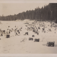 Stumps caused as a result of clear-cutting on the shore of the Raquette Lake Reservoir looking east. The dam is visible in the extreme distance, 1930s.