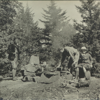 Two figures, possibly Theodore and Ethel Roosevelt, picnicking with a companion on Waltonian Island (which was squatted by Roosevelt friend William D’Alton Mann) on Lake George, NY. The girl who may be Ethel is sitting on a pack basket and all three figures are surrounding a campfire, circa 1902.